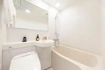 a white bathroom with a sink and a toilet at S-peria Inn Nihombashi Hakozaki in Tokyo