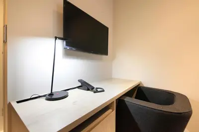 a room with a desk with a television and a chair at S-peria Inn Nihombashi Hakozaki in Tokyo