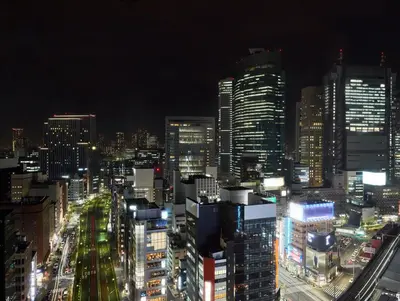 a city lit up at night with tall buildings at Dai-ichi Hotel Tokyo in Tokyo