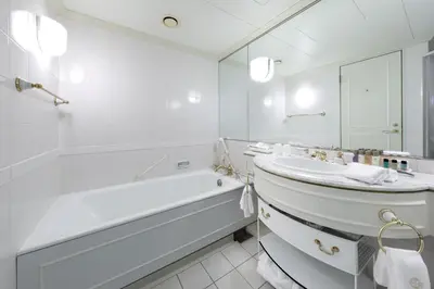 a white bathroom with a sink and a tub at Dai-ichi Hotel Tokyo in Tokyo