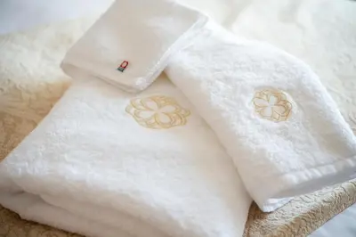 two white towels with flowers on them on a bed at Dai-ichi Hotel Tokyo in Tokyo