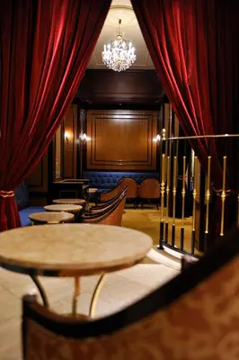 a row of tables and chairs in a room with red curtains at Dai-ichi Hotel Tokyo in Tokyo