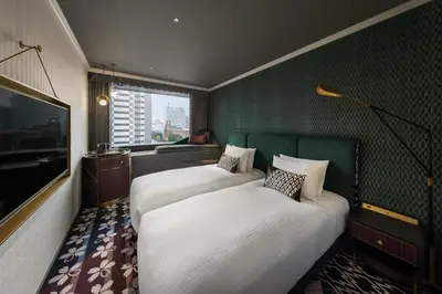 a hotel room with two beds and a television at Mercure Tokyo Hibiya in Tokyo