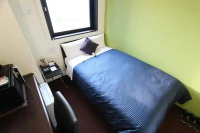a bedroom with a blue bed with a pillow at HOTEL LiVEMAX Ueno-Ekimae in Tokyo