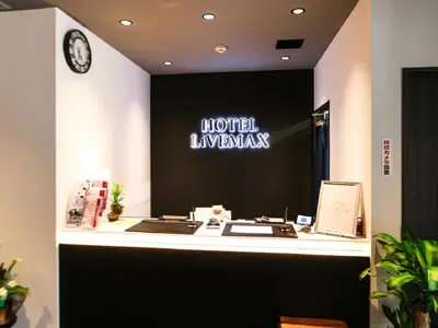 a hotel lobby with a reception desk with a clock at HOTEL LiVEMAX Akihabara Kita in Tokyo