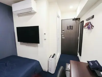 a room with a bed and a flat screen tv at HOTEL LiVEMAX Akihabara Kita in Tokyo