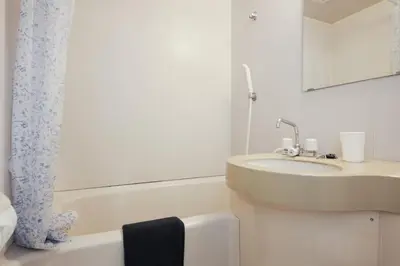 a white bathroom with a sink and a mirror at Urban Core Shikano 401 in Tokyo