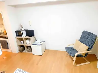 a living room with a chair and a microwave at Urban Core Shikano 501 in Tokyo