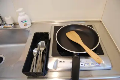 a frying pan on a stove with a wooden spoon at Urban Core Shikano 501 in Tokyo