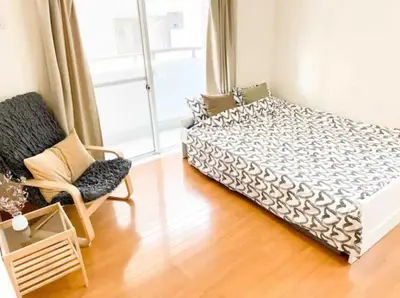 a bedroom with a bed and a chair and a window at Urban Core Shikano 501 in Tokyo