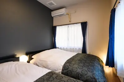 a bedroom with a bed and a window at Ryokan Ichinao in Tokyo