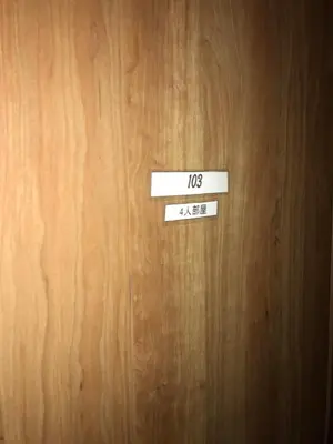 a wooden door with a sign on it at Ryokan Ichinao in Tokyo