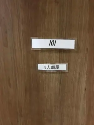 a wooden door with the number on it at Ryokan Ichinao in Tokyo