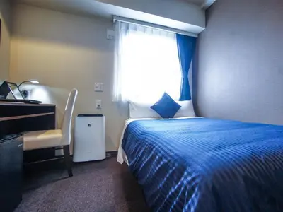 a bedroom with a blue bed and a window at HOTEL LiVEMAX Kasai Ekimae in Tokyo
