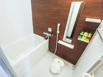 a bathroom with a tub and a toilet and a sink at HOTEL LiVEMAX Kasai Ekimae in Tokyo