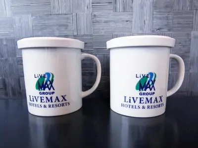 two white coffee cups sitting on a table at HOTEL LiVEMAX Tokyo Bakurocho in Tokyo