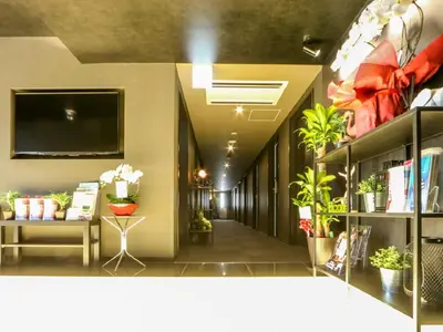a hallway with potted plants and a tv on the wall at HOTEL LiVEMAX Tokyo Shiomi Ekimae in Tokyo