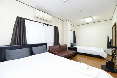 a hotel room with a bed and a couch and a chair at Evergreen hotel ichigaya luxe in Tokyo