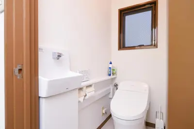 a bathroom with a toilet and a sink and a mirror at Evergreen hotel ichigaya luxe in Tokyo