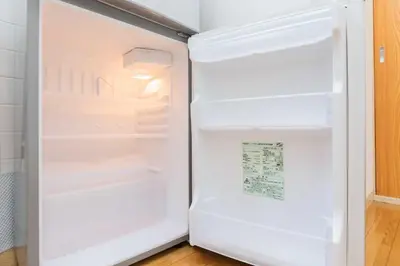 an empty refrigerator with its door open in a kitchen at Evergreen hotel ichigaya luxe in Tokyo