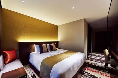 a hotel room with a large bed and a chair at The Gate Hotel Tokyo by Hulic in Tokyo