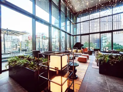 a lobby of a building with windows and plants at The Gate Hotel Tokyo by Hulic in Tokyo