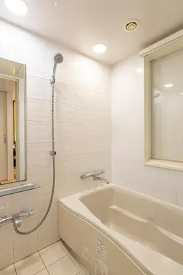 a bathroom with a shower and a tub and a sink at Hotel Keihan Tokyo Yotsuya in Tokyo