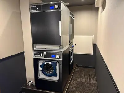 a washing machine with a tv on top of it at Hotel Keihan Tokyo Yotsuya in Tokyo