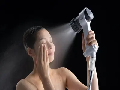 a man with no shirt holding a hair dryer at Nagomi House in Tokyo