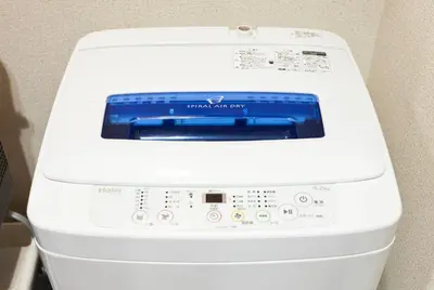 a washing machine with a blue screen on top of it at Nagomi House in Tokyo