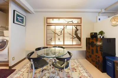 a dining room with a glass table and two chairs at Yoyogi House in Tokyo