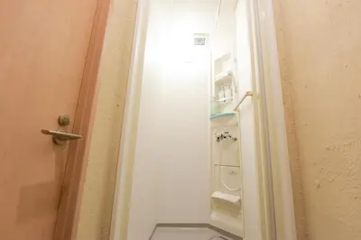 a door to a bathroom with a white refrigerator at Yoyogi House in Tokyo