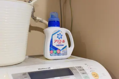a bottle of bleach sitting on top of a washing machine at Yoyogi House in Tokyo