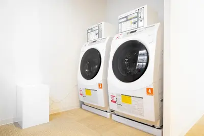 two washing machines sitting next to each other in a room at First Cabin Ichigaya in Tokyo
