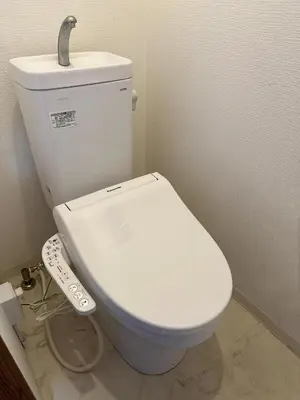 a white toilet in a bathroom with a remote control at Tokyo Kamakura House in Tokyo