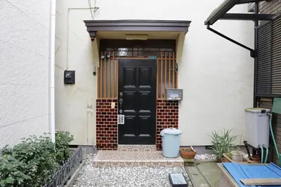 a black front door of a white house at Tokyo Kamakura House in Tokyo