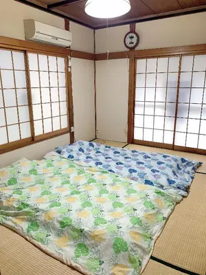a large bed in a room with windows at Tokyo Kamakura House in Tokyo