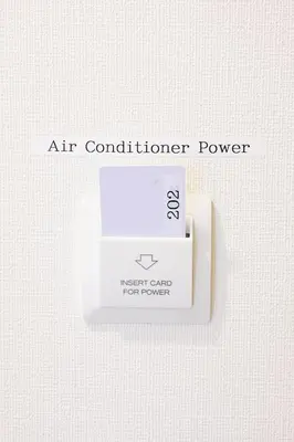 an air conditioning power box on a white wall at Oku Apartment in Tokyo