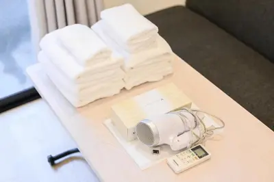 a table with towels and a hair dryer and a fan at Oku Apartment in Tokyo