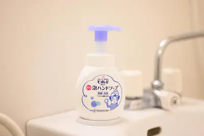 a bottle of detergent sitting on top of a sink at Oku Apartment in Tokyo
