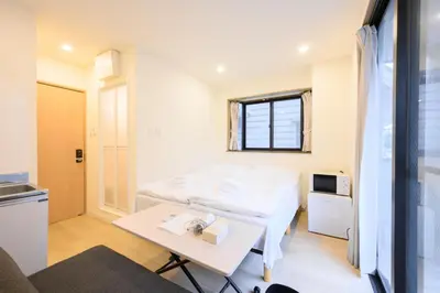 a room with two beds and a table at Oku Apartment in Tokyo