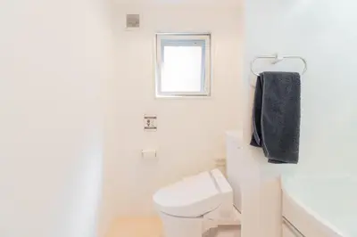 a white bathroom with a toilet and a window at The Emilio 102 Shinjuku Near Shibuya in Tokyo