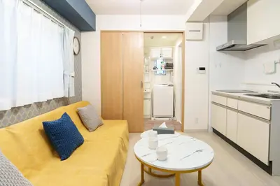 a living room with a yellow couch and a table at The Emilio 102 Shinjuku Near Shibuya in Tokyo