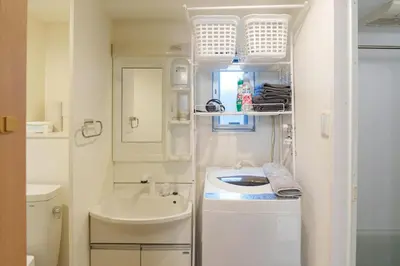 a small white bathroom with a sink and a mirror at The Emilio 102 Shinjuku Near Shibuya in Tokyo
