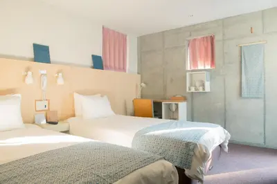 a hotel room with two beds and a table at DOMO Hotel in Tokyo