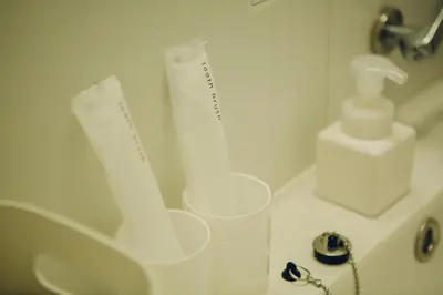 a bathroom with a sink and a bottle of toothpaste at DOMO Hotel in Tokyo