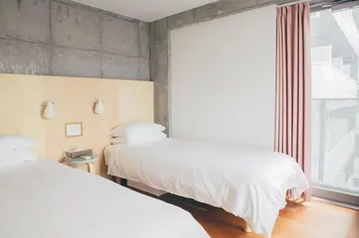 two beds in a room with a window at DOMO Hotel in Tokyo
