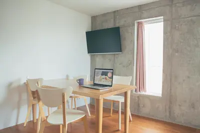 a dining room with a table with a laptop on it at DOMO Hotel in Tokyo