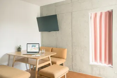 a room with a table and chairs and a laptop at DOMO Hotel in Tokyo