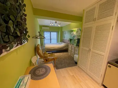 a bedroom with a bed and a desk in a room at only 2 stops to shibuya sangenjaya apt in Tokyo